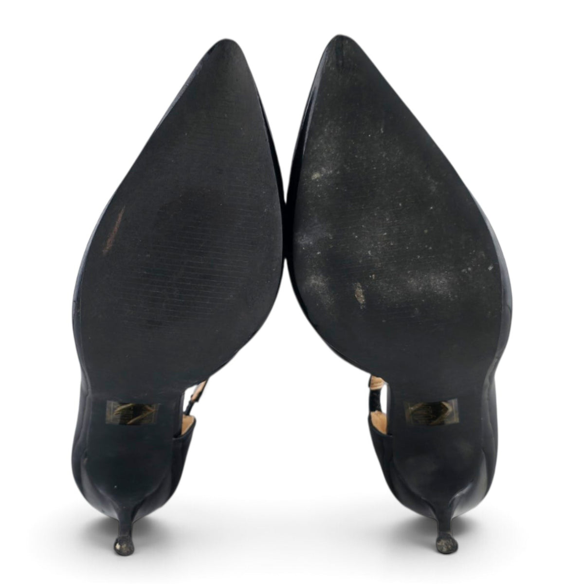 FuzzBeez black patent pointed toe stiletto pumps showing the synthetic soles from a bottom view