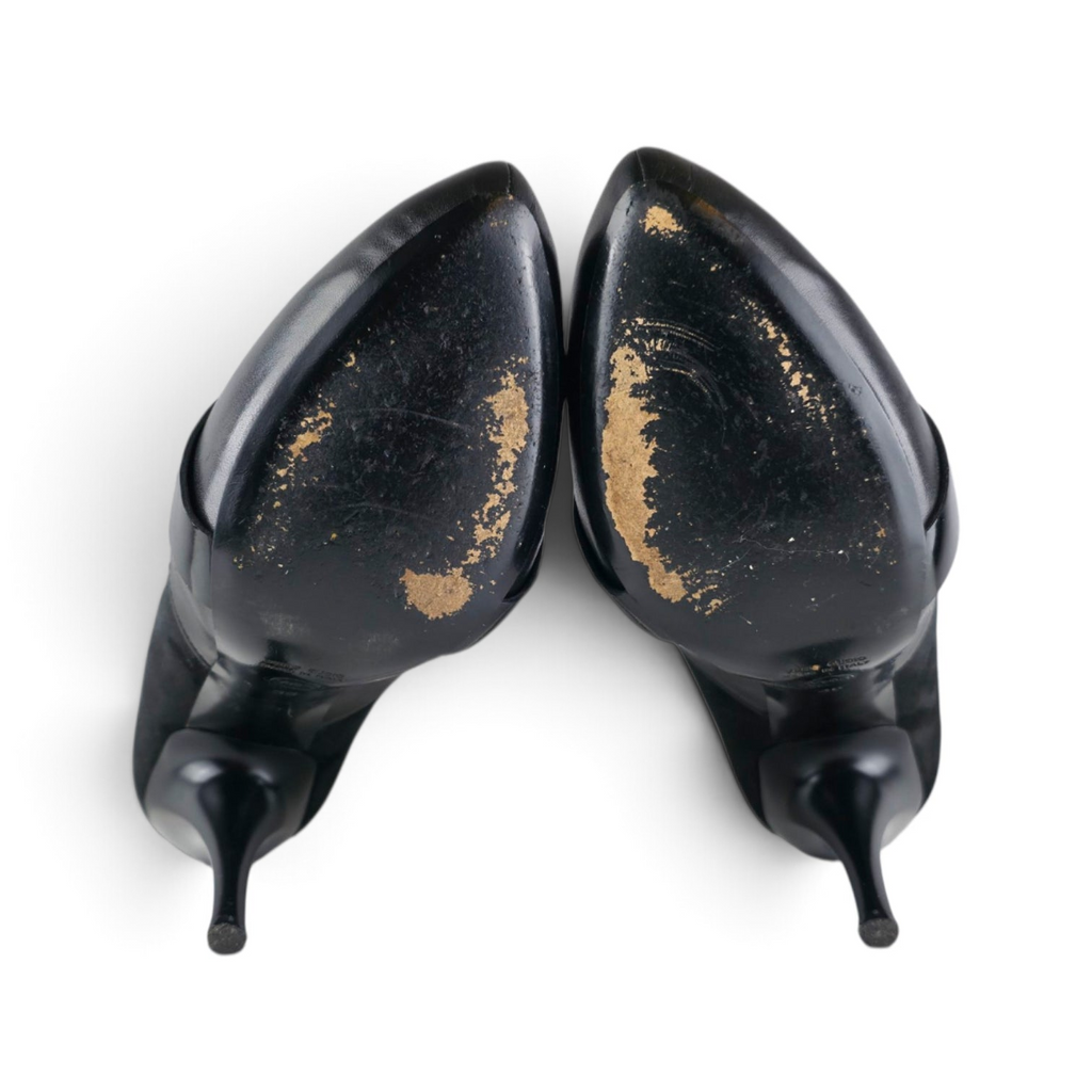 FuzzBeez Viktor & Rolf black leather and suede stiletto pumps showing worn leather soles from a top-down view